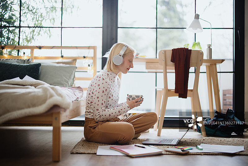 戴耳机用笔记本电脑在线学习的女学生图片素材