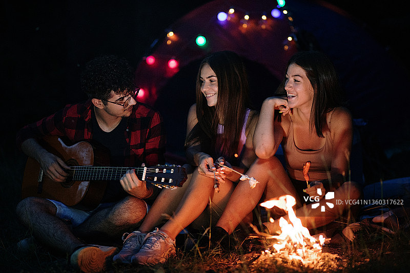朋友们在篝火旁弹吉他露营图片素材