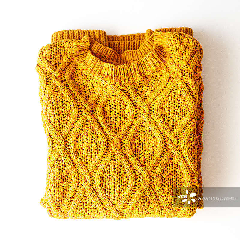 桌子上折叠的黄色毛衣俯视图图片素材
