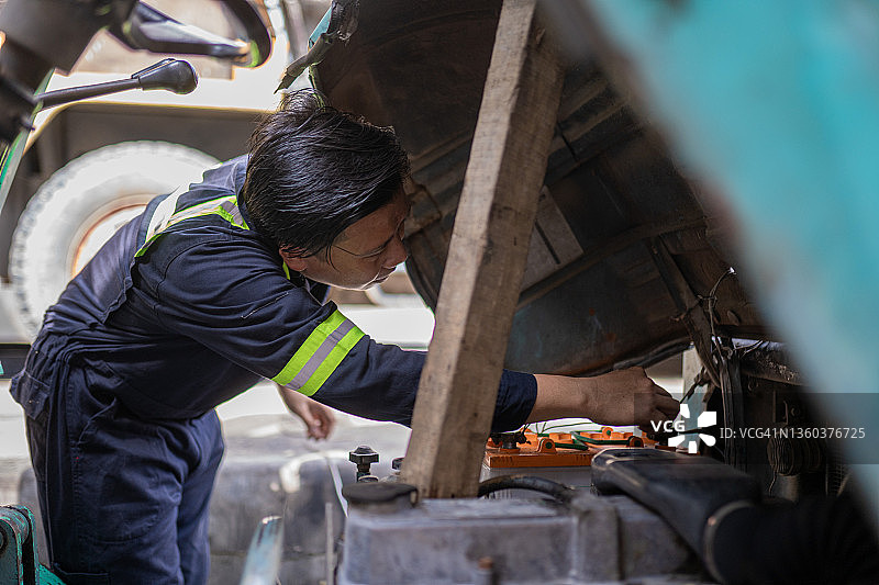 亚洲华人机械师在修理店检查卡车发动机图片素材