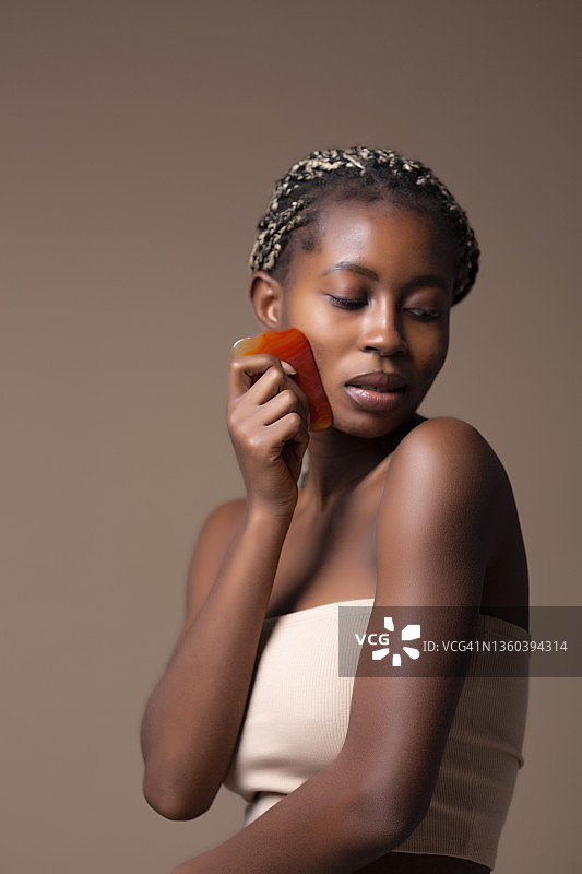 年轻的非洲裔女人用刮痧板图片素材