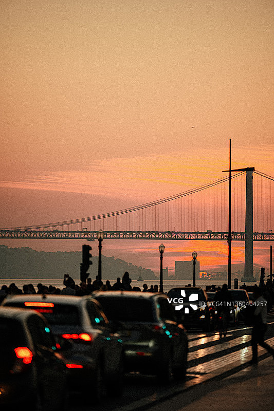 里斯本拜萨区，悬索桥背景下的交通拥堵日落景色图片素材