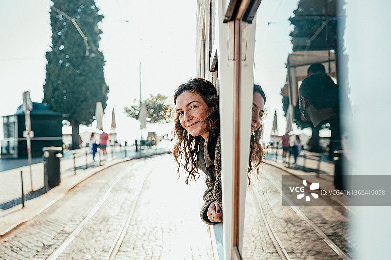 女人从有轨电车的窗户探出身子图片素材