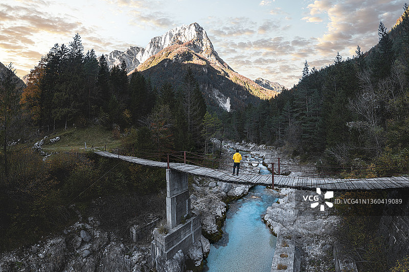男人站在山河之上的悬索桥上图片素材