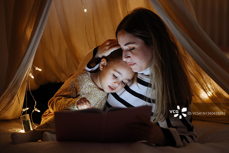 睡前，母子在床上一起读书图片素材