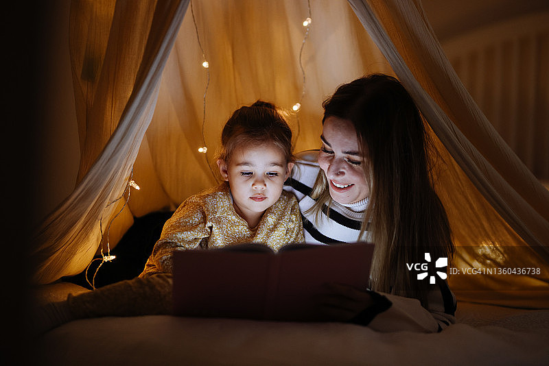 睡前，母子在床上一起读书图片素材