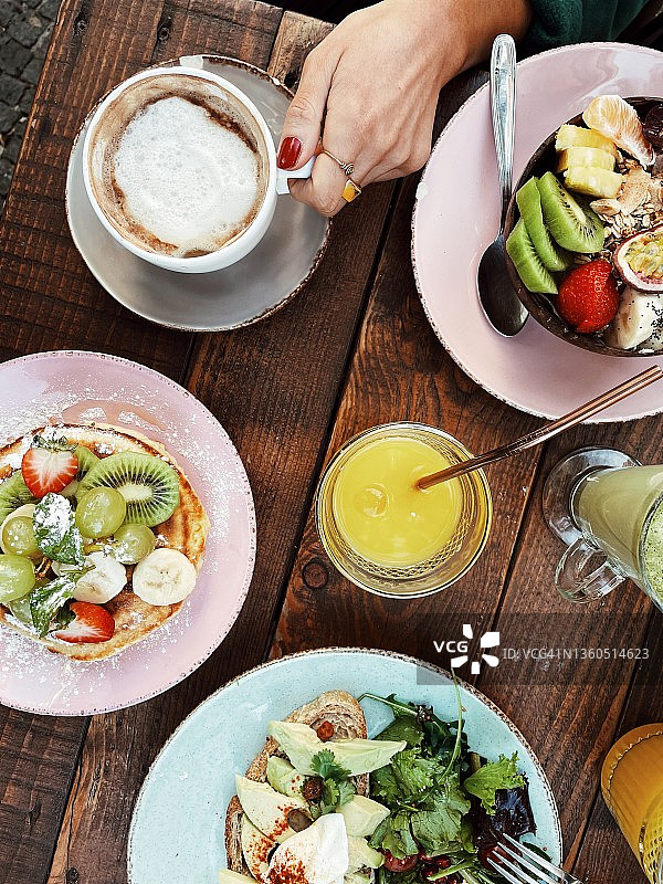俯视乡村风格的早午餐餐桌，可见女性的手图片素材