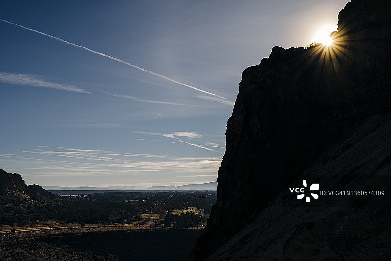 阳光明媚的一天，在俄勒冈州中部，太阳越过一个引人注目的剪影山峰图片素材