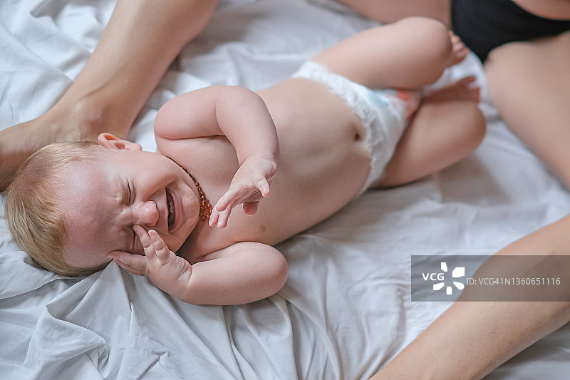 在床上哭闹的不舒服的男婴图片素材