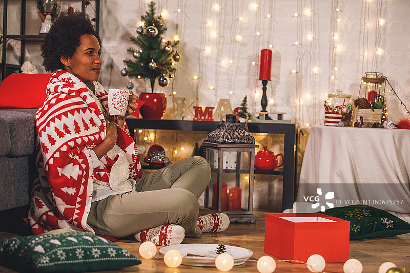 裹着毯子在地板上享受茶的快乐女人图片素材