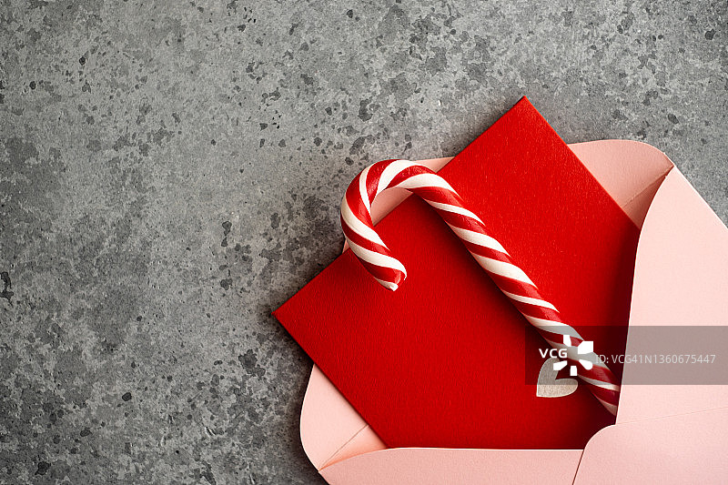 粉色信封、红色明信片和拐杖糖特写，情人节贺卡，俯视图图片素材