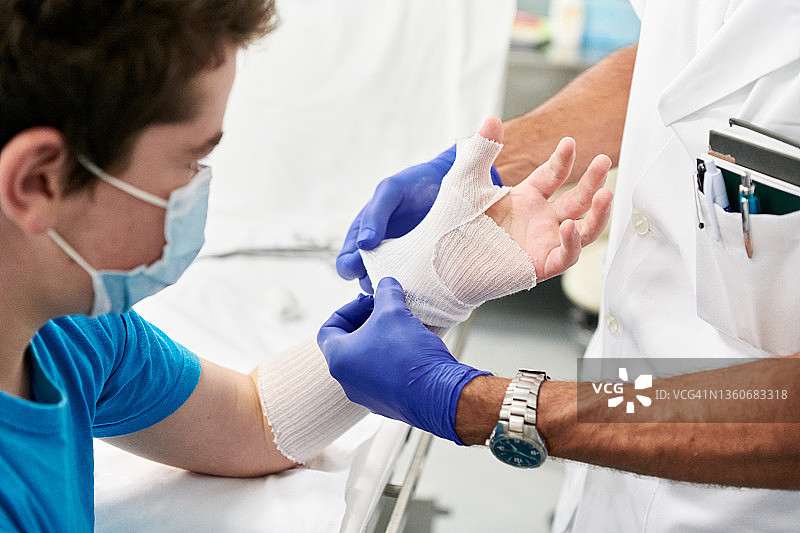 青少年在医生办公室准备为手部进行石膏固定图片素材
