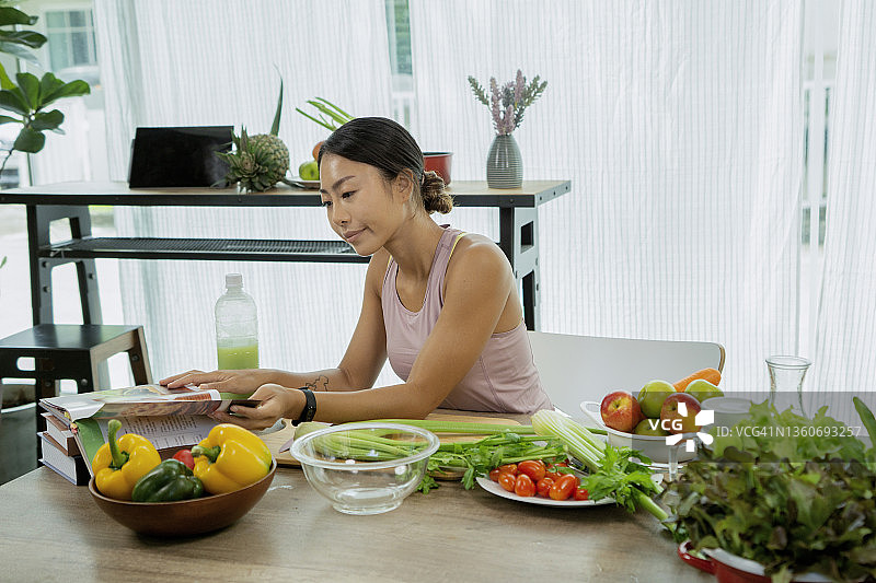 年轻女子按照食谱烹饪图片素材