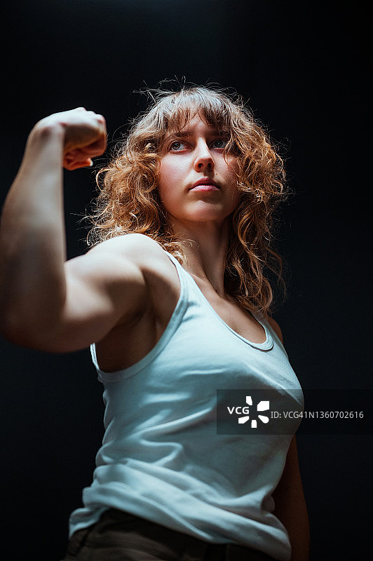 展示手臂力量的年轻女性肖像图片素材
