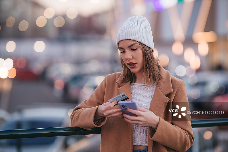 女孩拿着信用卡发短信图片素材