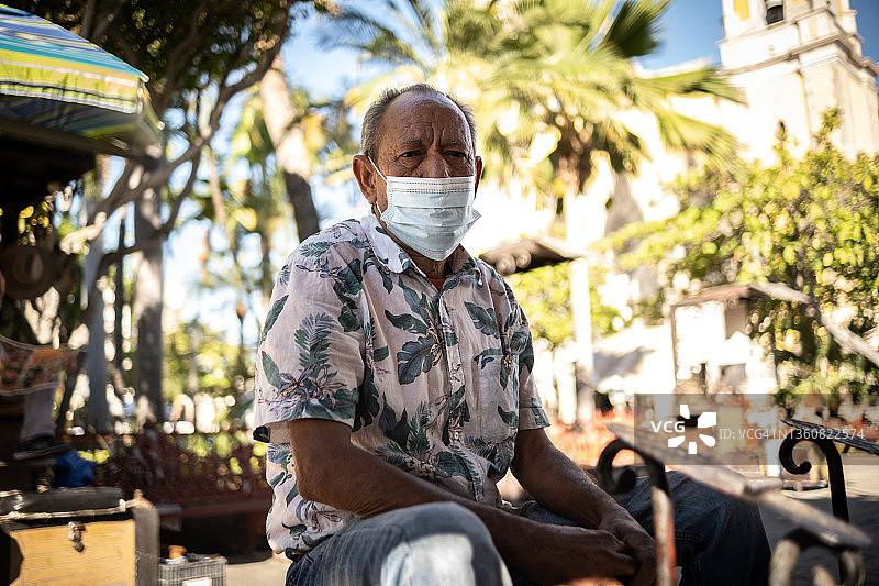在户外擦鞋、戴着口罩的中年男人肖像图片素材