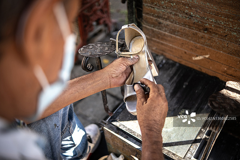 中年男人在户外用口罩抛光凉鞋的双手特写图片素材