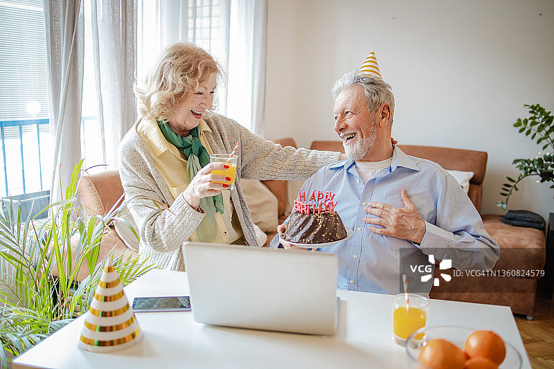 老年夫妇在家中通过视频通话庆祝生日图片素材