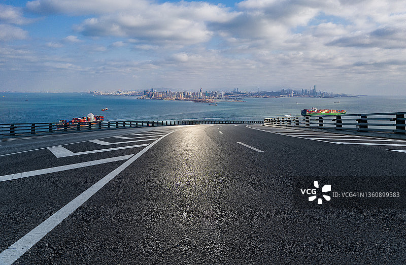 汽车广告背板，青岛城市天际线前的空旷道路图片素材