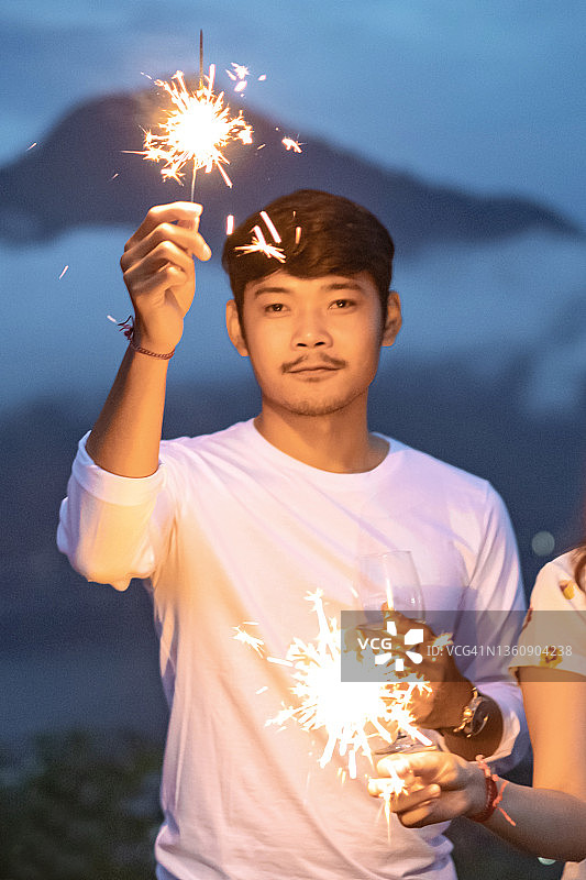 新年夜庆祝活动上手持烟花的男子图片素材