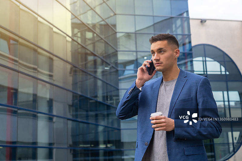 年轻白人商人工作休息时间在办公室外打电话。金融人士和商业企业家图片素材