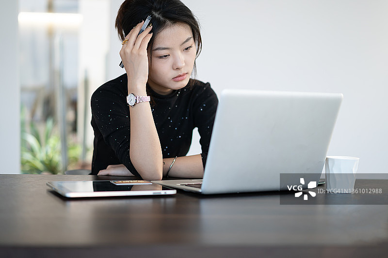 办公室里，亚裔年轻女白领面露疲惫图片素材