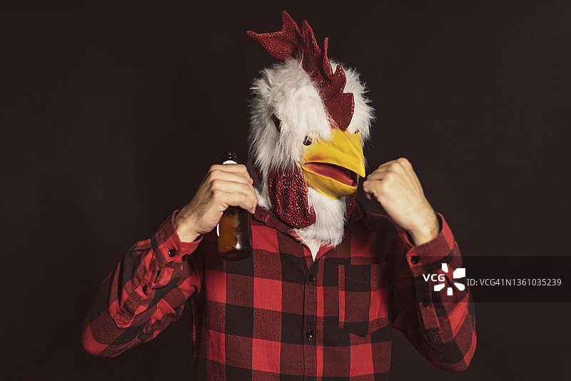 穿鸡服装的男人在演播室肖像中准备战斗并喝啤酒图片素材