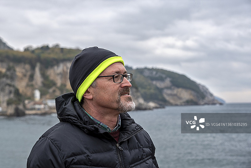 海滩边沉思的老年男人肖像图片素材