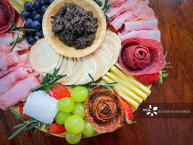 伊比利亚火腿、萨拉米香肠、切达奶酪、绿葡萄、草莓、山羊奶酪和松露酱图片素材