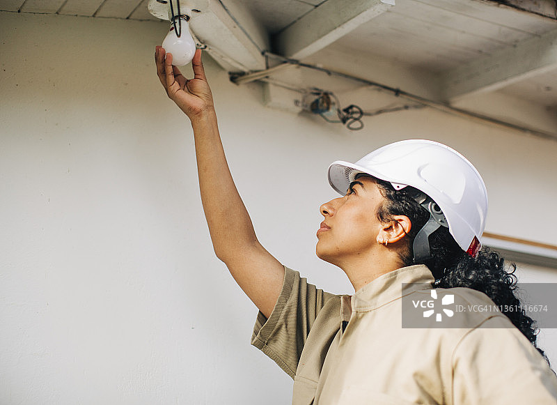 女电工安装荧光灯泡图片素材