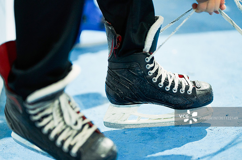 男人在溜冰前系紧冰鞋，运动概念图片素材