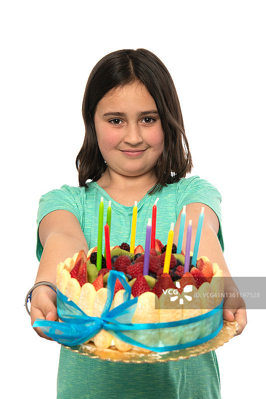 微笑的小女孩拿着生日蛋糕在白色背景前摆姿势图片素材