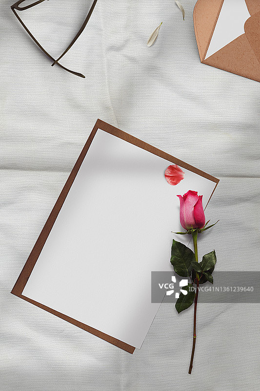 女士婚礼文具花卉桌面样机场景：空白贺卡、工艺信封和玫瑰枝图片素材