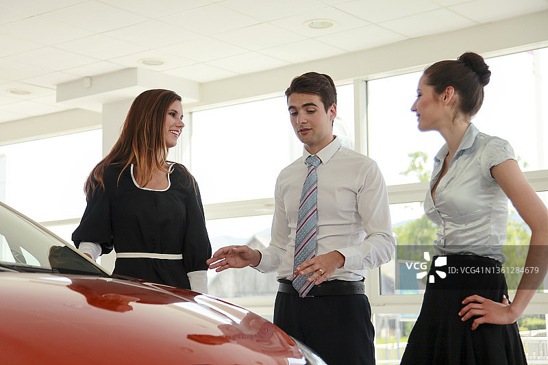 年轻女人和朋友一起买新车图片素材