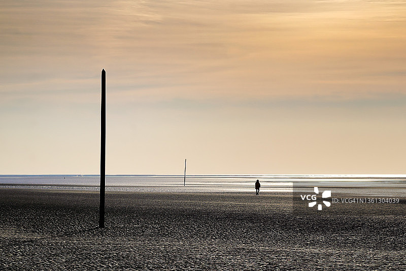 在法国诺曼底冬季的海滩上行走的女人图片素材