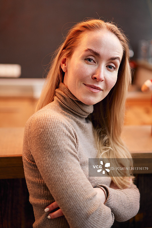 自信的女人在咖啡馆柜台旁图片素材