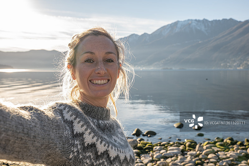 在湖边给婴儿自拍的女人图片素材