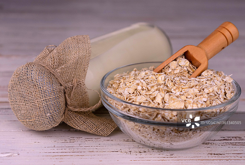 白色木质背景上的瓶装无乳糖燕麦奶图片素材