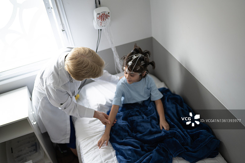 医生在多导睡眠监测（睡眠研究）前与男孩交谈图片素材