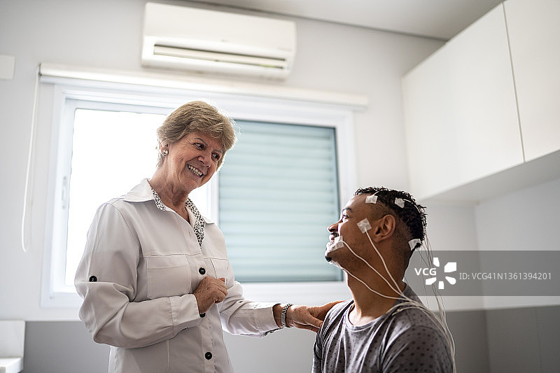 医生在多导睡眠监测（睡眠研究）前与患者交谈图片素材