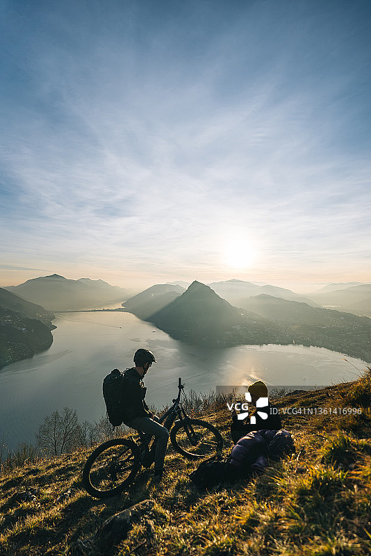 山地自行车骑行者在草地山脊上放松图片素材