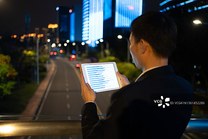 数字平板上的商业报告，男子夜晚使用数字平板图片素材