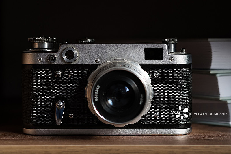 旧式复古胶片相机、木架上的老式相机和书本，摄影师的工作场景，兴趣爱好概念图片素材