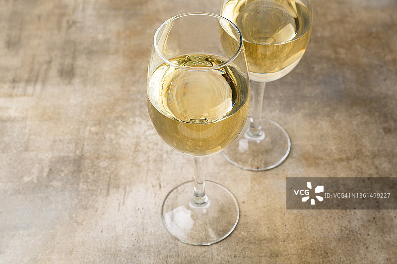 两杯白葡萄酒，棕色背景上的酒杯图片素材
