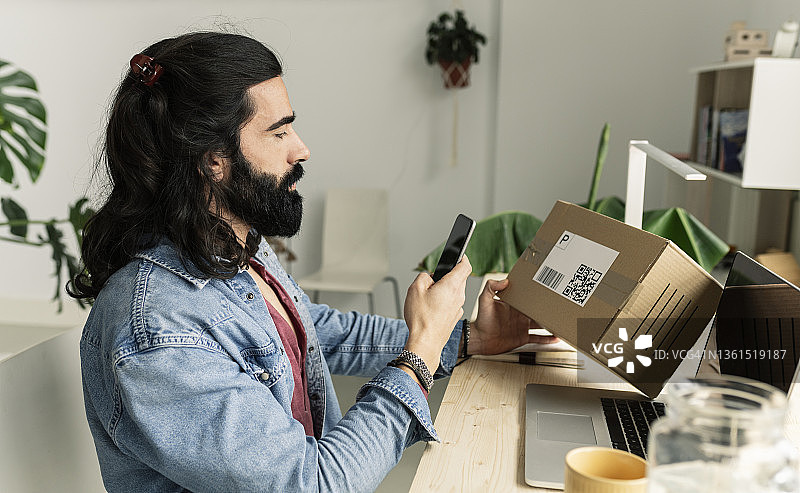 在家寄送带二维码包裹的男人图片素材