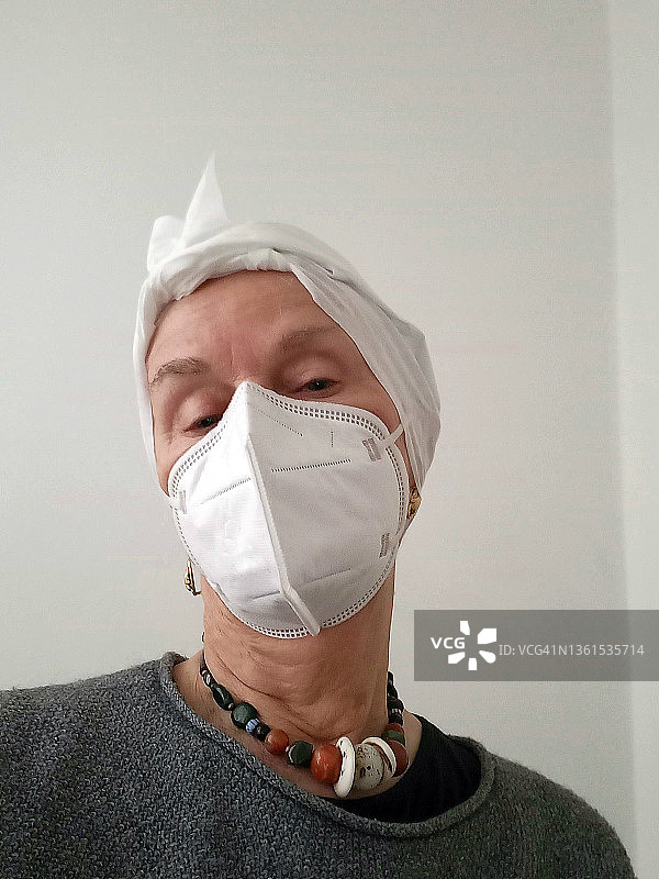 戴着口罩和头巾的年长女性图片素材