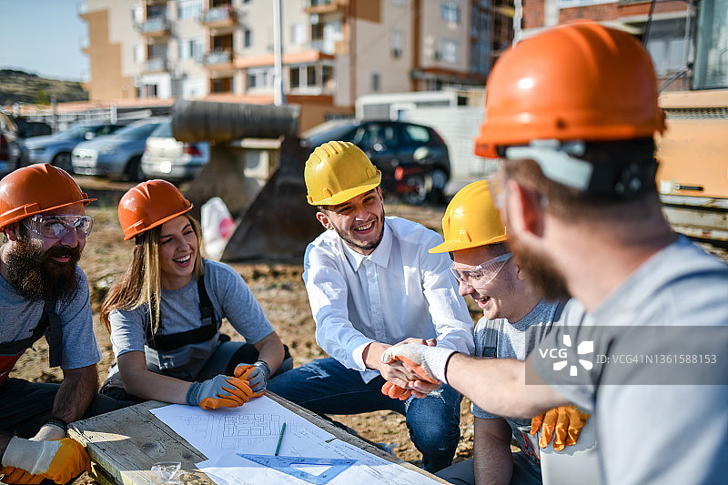 建筑师在现场与土木工程师和建筑工人会面，讨论蓝图图片素材