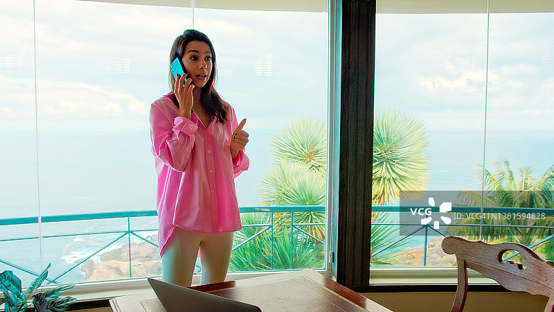 在全景窗边工作，进行史诗海景商务通话的女人图片素材
