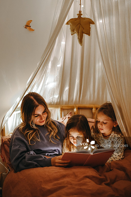 母女睡前在床上看书图片素材