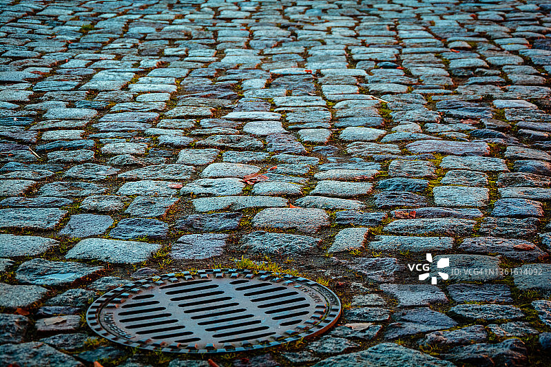 鹅卵石街道上的井盖图片素材